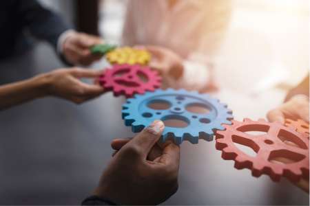 People holding cogs together illustrating an integrated system