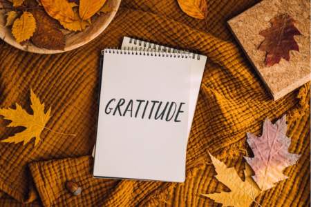 Gratitude written on a notepad surrounded by Thanksgiving decoration