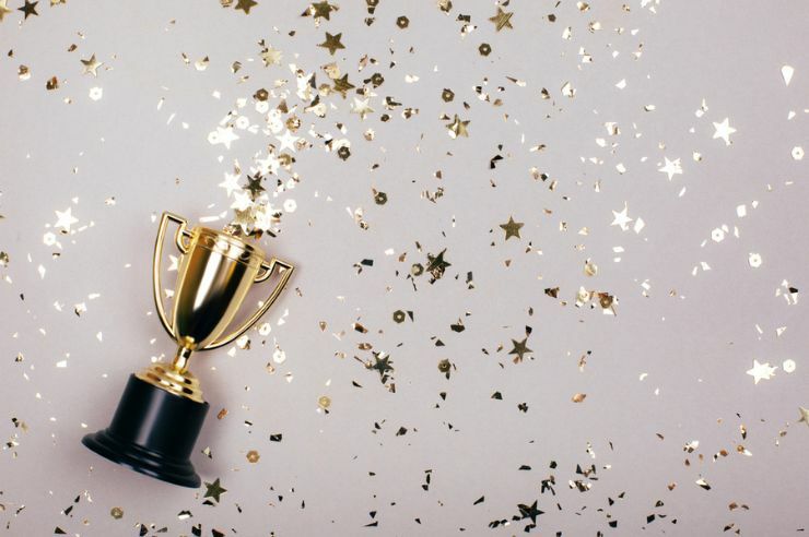 An image with a trophy and confetti for an award