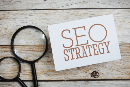 Paper that says "SEO strategy" next to  magnifying glass