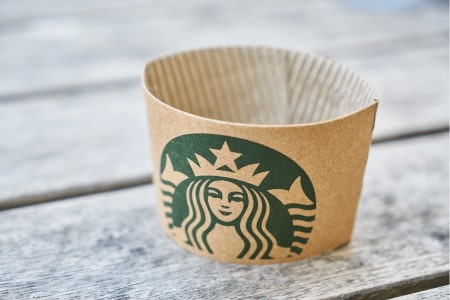 A Starbucks coffee sleeve on a wooden table