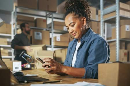 Person on the phone in shipping center using an inventory management automation tool