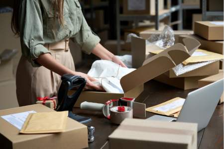 Person packing boxes in a shipping and fulfillment center