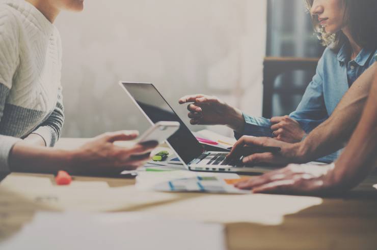 Workers at a startup developing an eCommerce store on a laptop