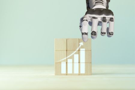 Robotic arm stacking blocks depicting a bar graph that is increasing exponentially