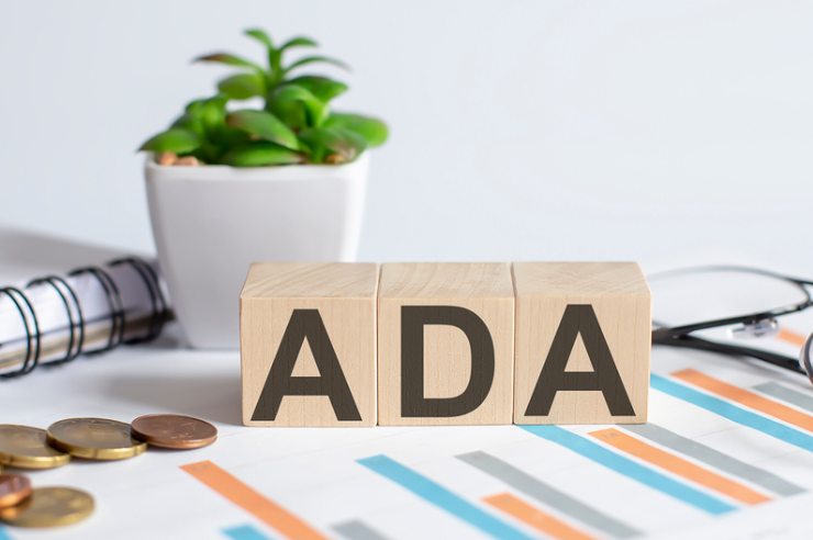 “ADA” spelled out in wooden blocks surrounded by office supplies