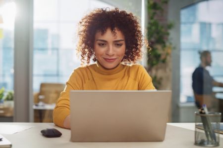 Smiling person on laptop researching ADA alt text best practices