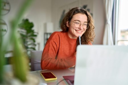 A smiling freelance digital marketer using a laptop