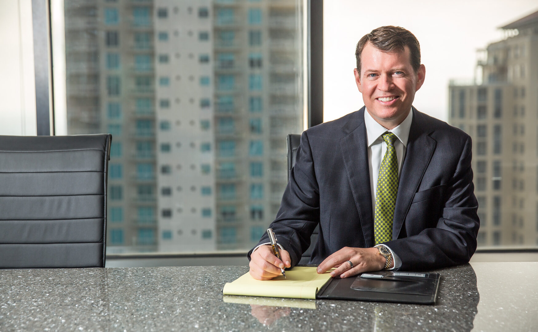 A lawyer sitting at a desk writing on a legal pad