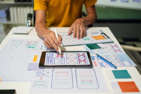 Person drafting mobile layouts at desk