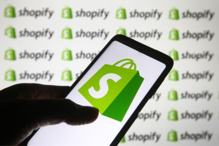 Smartphone with Shopify logo onscreen and in background