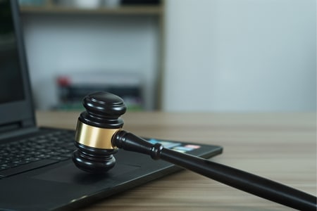 A gavel resting on a laptop keyboard