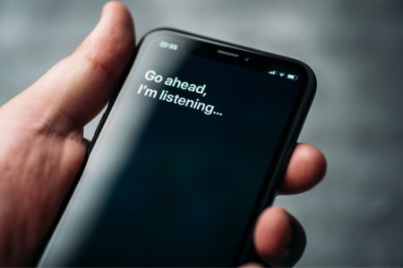 Man holding phone waiting for a voice command input.