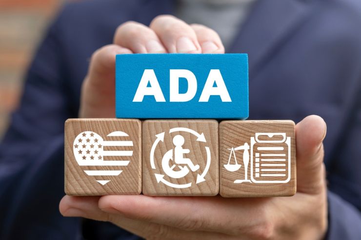 Man holding ADA blocks with disability icons.
