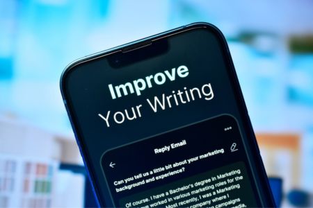 Mobile phone displaying improve your writing text.