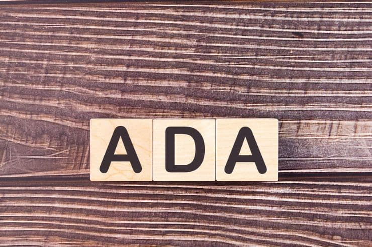 Wooden blocks with ADA text on desk.