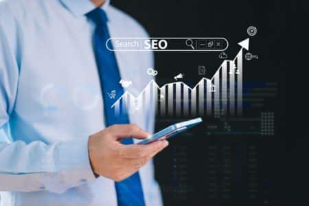 A man holding a mobile phone behind an SEO chart visualization.