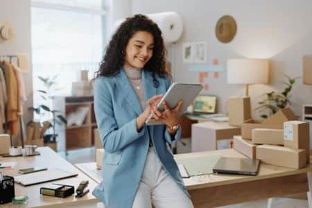 A happy businesswoman reviews her business product inventory.