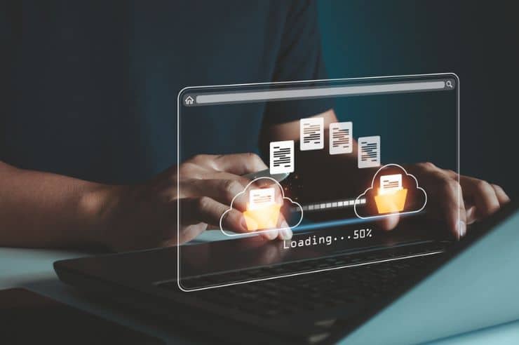 hands using a laptop with a digital loading screen overlay