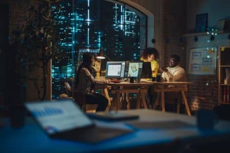 creative team working late in modern office with city lights in background