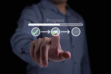  hand pointing at digital progress tracker with checkmarks