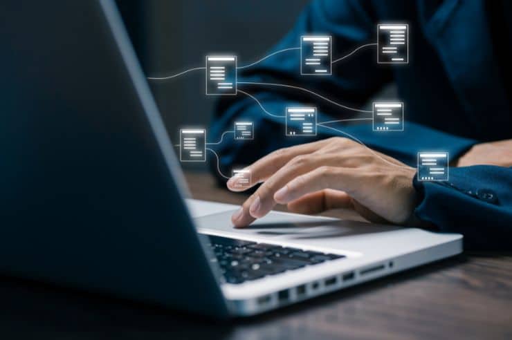 man typing on laptop with visuals of screens coming from laptop