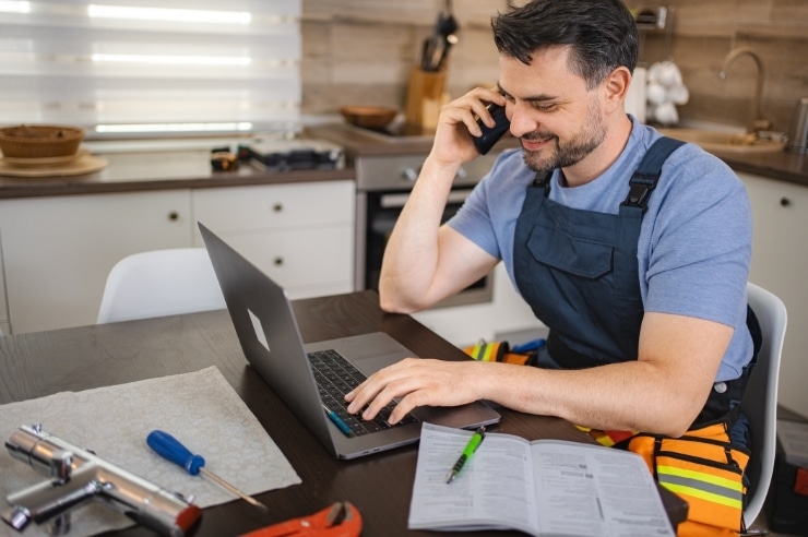 repair man researching marketing for home services on laptop