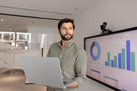 business professional presenting analytics on screen.
